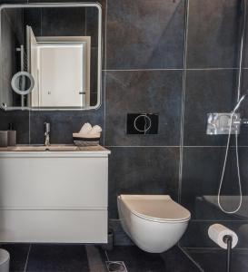 bagno con servizi igienici, lavandino e specchio di Valeria's Sea View Apartment ad Atene