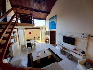 a living room with a staircase and a living room with a table at Deu praiabuzios in Búzios