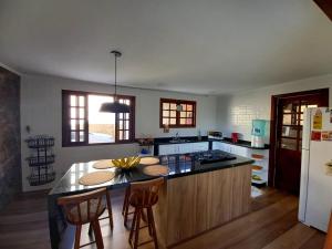 a kitchen with a island in the middle of a room at Deu praiabuzios in Búzios
