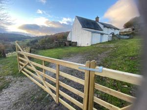 a wooden fence in front of an old house at Ffawydden - a listed gem in the National Park in Abergavenny