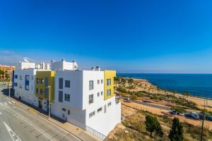 a building on the side of a road next to the ocean at La Punta COLORS By DLV in Villajoyosa