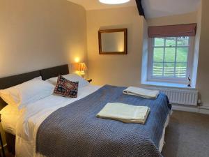 ein Schlafzimmer mit einem Bett mit zwei Handtüchern darauf in der Unterkunft Ffawydden - a listed gem in the National Park in Abergavenny