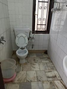 a bathroom with a toilet and a sink and a window at zoz sm 5 in Shimla
