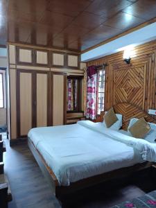 a bedroom with a large bed with a wooden headboard at zoz sm 5 in Shimla