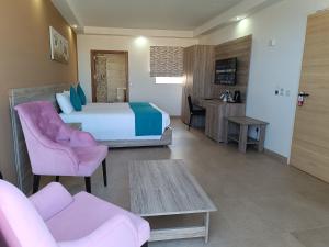 a bedroom with a large bed and a living room at TJ Boutique in Marsaskala