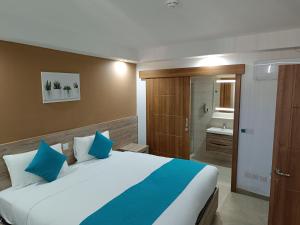 1 dormitorio con 1 cama grande y baño en TJ Boutique, en Marsaskala