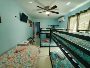a bedroom with two bunk beds and a ceiling fan at Chic 3 Bedroom Unit, Few Steps To The Ocean, Barbosa Unit 4 in Catano