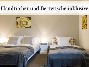 two beds in a room with avertisement for at Blumenvilla 2 mit begehbarer Dusche, Sauna, Garten in Schneverdingen