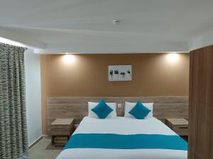 a bedroom with a large bed with blue pillows at TJ Boutique in Marsaskala
