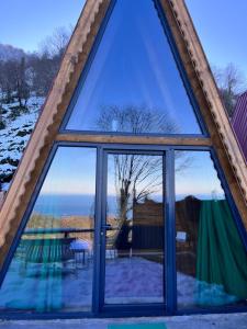una gran ventana en una cabaña con vistas al océano en Pagen Bungalow, en Artvin