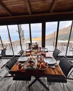 una mesa con comida en ella con sillas alrededor en Pagen Bungalow, en Artvin