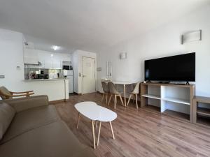 a living room with a couch and a table and a kitchen at Michelangelo - PlanetCostaDorada in Salou