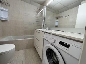 a bathroom with a washing machine and a toilet at Michelangelo - PlanetCostaDorada in Salou