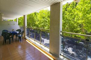 a balcony with a table and chairs and trees at Michelangelo - PlanetCostaDorada in Salou