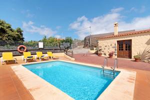 een zwembad met gele stoelen en een huis bij Casa Rural Tinamar in Vega de San Mateo