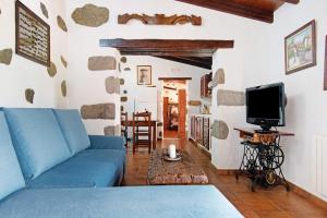 sala de estar con sofá azul y TV en Casa Rural Tinamar, en Vega de San Mateo