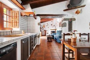 貝加德聖馬特奧的住宿－Casa Rural Tinamar，厨房以及带桌子和沙发的客厅。