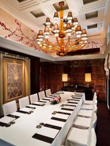 a long table in a room with white chairs and a chandelier at The Fullerton Bay Hotel Singapore in Singapore