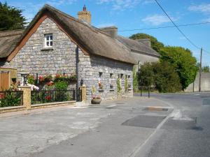 une vieille maison en pierre avec des fleurs dans une rue dans l'établissement Clonmacnoise B&B, à Clonmacnoise