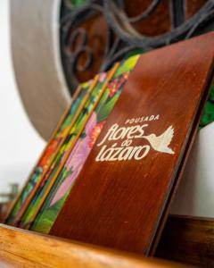 a wooden bench with a sign that says passion hopes to london at Pousada Flores do Lázaro in Ubatuba