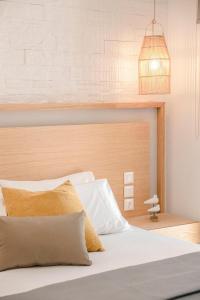 una camera da letto con un letto bianco con testiera in legno di Villa Christina - Ionian Treasure Villas ad Argostoli