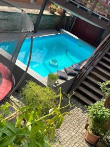 einen Blick über einen Pool mit Stühlen und Treppen in der Unterkunft Einzimmerapartment mit Fass Sauna (und Pool) in Fränkisch-Crumbach