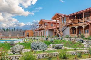 una casa de madera con una piscina frente a ella en Serodani, en Telavi