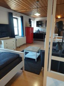 Habitación con cama y sala de estar con mesa. en Zentral Appartement en Landsberg am Lech