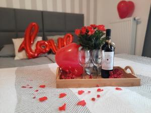 克拉科夫的住宿－Royal Smart Apartments Cracow，桌子上放着红桃的一瓶葡萄酒和玻璃杯