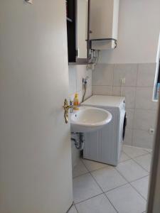 a bathroom with a sink and a washing machine at Zentral Appartement in Landsberg am Lech