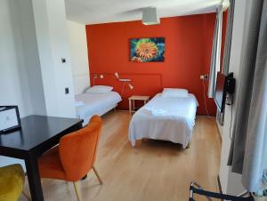 una habitación con dos camas y un escritorio y una mesa en Hotel Saint Vincent, en Poeldijk