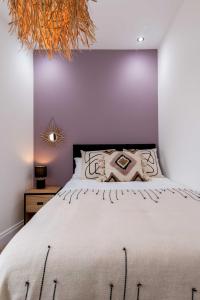 拉格比的住宿－Railway Apartments Rugby，一间卧室配有一张带白色床罩的大床