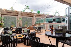 an outdoor patio with tables and chairs and stairs at Hotel Dan Inn Uberlandia in Uberlândia
