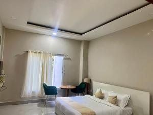 艾藻爾的住宿－HOTEL RANSAM，一间卧室配有一张床、一张桌子和一个窗户。