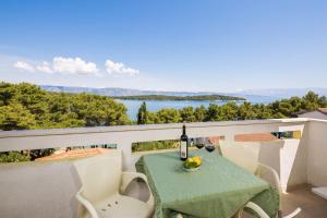 - une table avec une bouteille de vin sur le balcon dans l'établissement Apartments Poklepović, à Jelsa