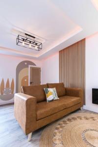 a living room with a brown couch and a television at Railway Apartments Rugby in Rugby