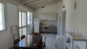 uma cozinha com uma mesa e uma mesa e cadeiras em La Rosa dei Venti em Teulada