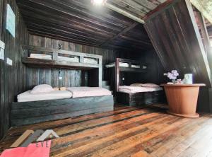 Duas camas num quarto com paredes de madeira em Tim Seaside Resort by Evernent em Miri