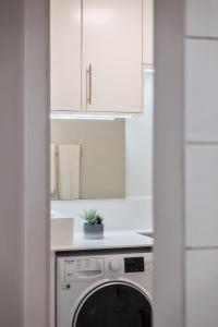 uma cozinha branca com uma máquina de lavar louça e um armário branco em Imperatriz I - By wehost no Funchal
