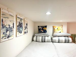 Habitación con 2 almohadas en la pared y cuadros. en Koenji loft apartment/Shinjuku&Kichijoji/JR, en Tokio