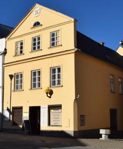 żółty budynek z zegarem na boku w obiekcie Apartman pod Zamkem w Javorníku