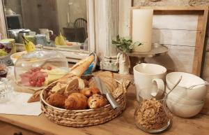 - une table avec un panier de pain et une bougie dans l'établissement Le Lodge des Flâneurs, à Vielsalm