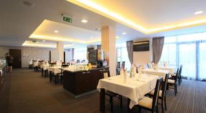 a dining room with tables and chairs with white table cloth at Apartman Panorama 1001 in Štrbské Pleso