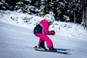 a young child is skiing down a snow covered slope at Hunderfossen Apartments in Hafjell