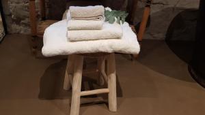 una pila de toallas sentadas encima de un taburete en Le Lodge des Flâneurs, en Vielsalm