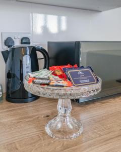 a glass tray with books on a counter next to a microwave at Contractors I Working professionals I Relocators - Near Train Station and Airport in Luton