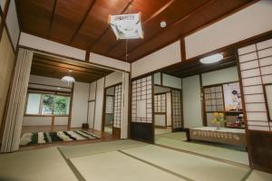 an empty room with a clock on the ceiling in a room with windows at Vacation Rental あんばええ in Nakatsugawa