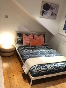 een bed met kussens in een kamer bij Fabulous Central Studio Apartment - Flat 4 Highbury in Londen