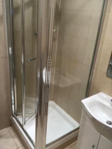 a shower with a glass door next to a sink at Fabulous Central Studio Apartment - Flat 4 Highbury in London