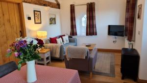 a living room with a couch and a table with flowers at Mountain View in Ulverston